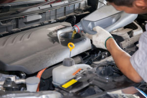 mechanic performing fluid flush in vehicle Lake Arbor Automotive & Truck Westminster Colorado