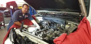 Auto Repair & Maintenance mechanic working under hood of car Lake Arbor Automotive Westminster