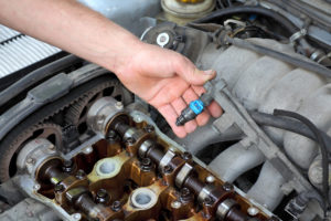 mechanic showing fuel injector in vehicle Lake Arbor Automotive & Truck Westminster Colorado